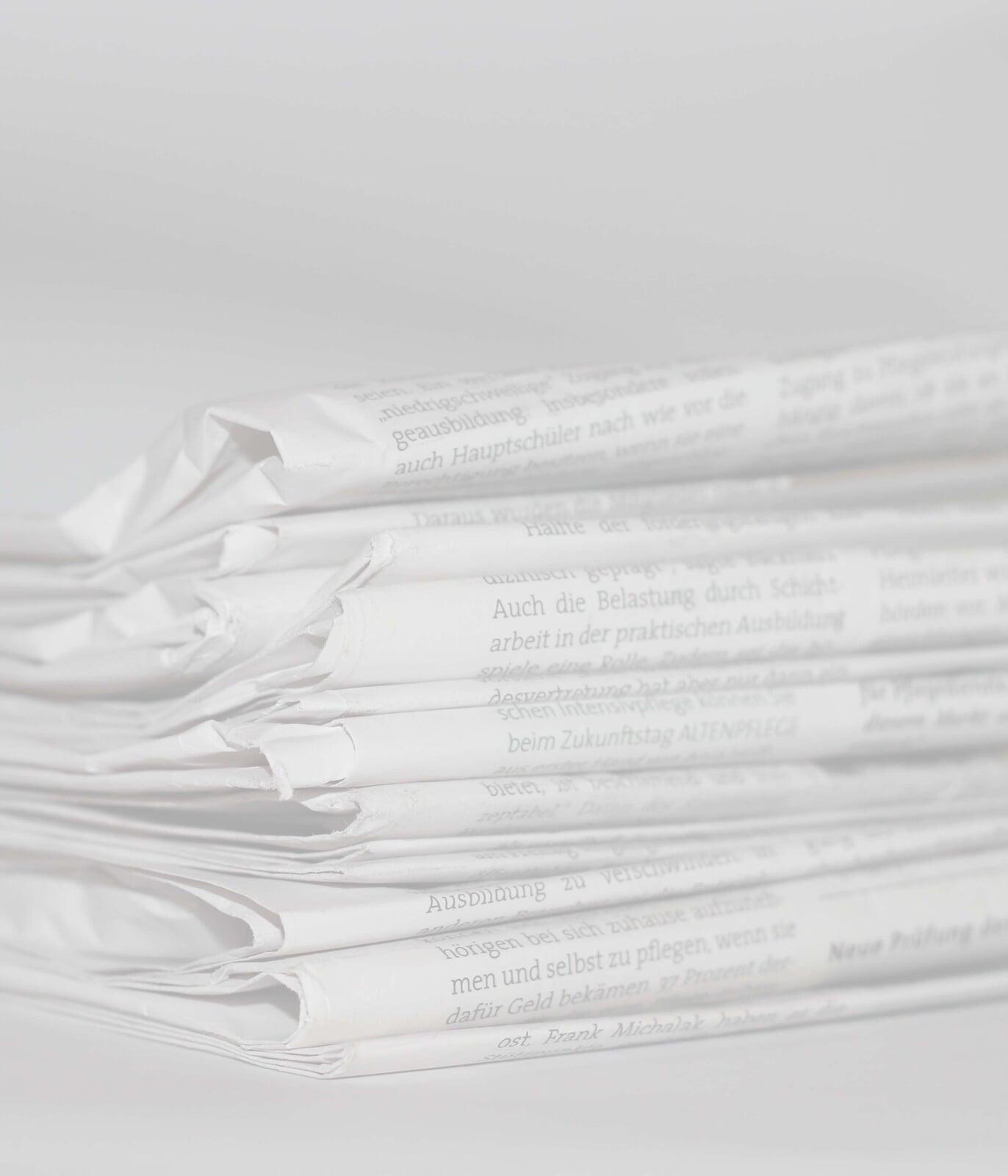 Zeitungsstapel repräsentieren Newsletter, die regelmäßig erscheinen